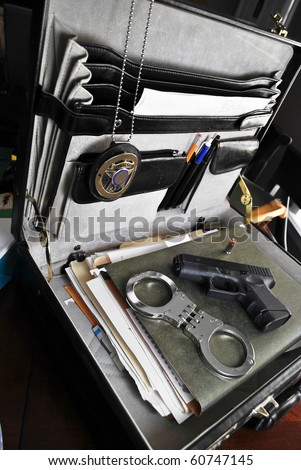 Law enforcement tools of the trade, briefcase, paperwork, handcuffs, firearm, and badge/Law & Order