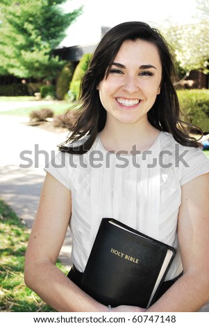 Young women smiling while holding a Bible/Young Woman Holding a Bible