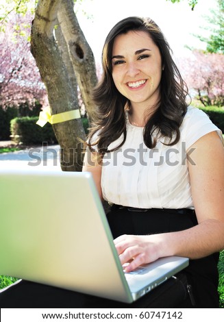 Young woman smiling while holding a laptop/Young Woman Smiling with Laptop