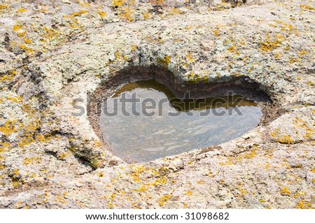 stone granite heart with puddle and moss