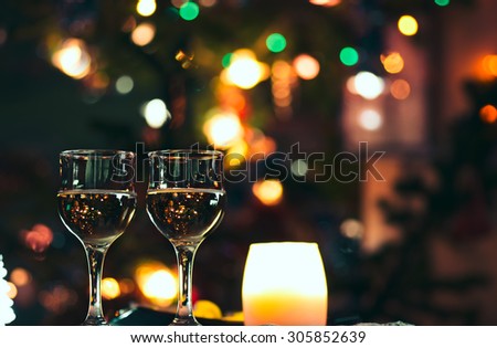 Two glass glasses with drink standing on a table.