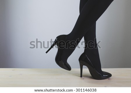 Young woman\'s legs in high-heeled black shoes - close-up photo