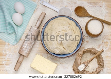 Baking background. Preparation of the dough. Accessories for preparation of the dough: sieve, rolling pin, board, spoon. Food, ingredients for making dough, eggs, butter, flour, sugar.