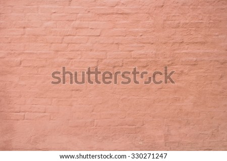 Stucco over brick wall. Plaster warm terracotta color on a brick wall. ?lose-up detail of rustic textured. Warmly toned mediterranean facade, wall with painted structured plastering.