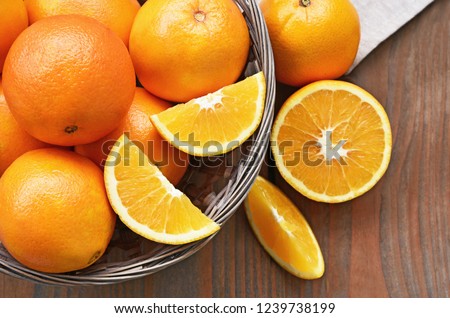 A lot of Navel Orange full and slice in basket on wooden background.