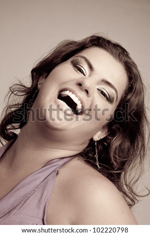 Female Plus size model posing in the studio, duotone face portrait, on grey background. The woman is smiling in a happy manner. Good for concept of health, happiness, dieting, obesity, weight loss.