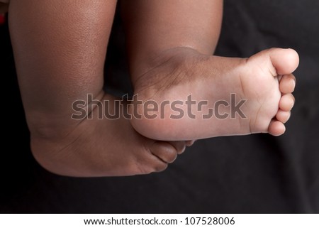 Newborn baby\'s feet. A closeup with a candid appeal. The baby skin is african brazilian tone.