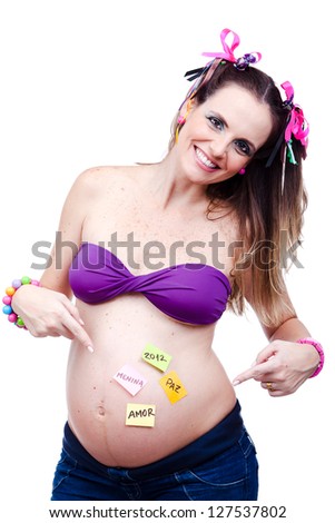 Beautiful pregnant woman, a model, with some positive messages in her belly, wearing colorful ribbons and bracelet, purple bra and jeans.
