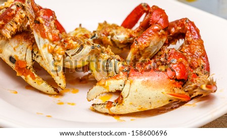 Brazilian crab on light pink plate, with tomato sirup and onion. Brazilian sea food.