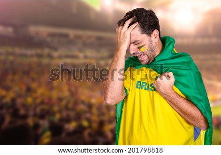 Brazilian soccer fan or supporter crying in the championship or competition or cup.