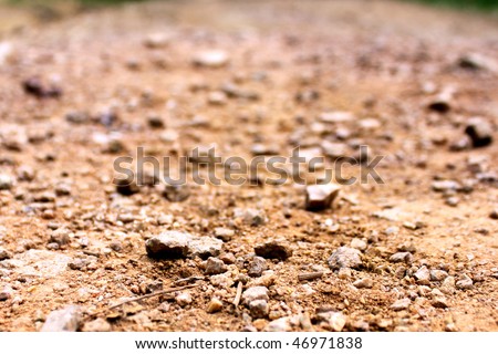 Terrain small road with small rocks on the ground viewed from near the ground. Can be used as a background, texture or wallpaper. Can be used as a concept of dead, dirty, recoverable, ecology, etc