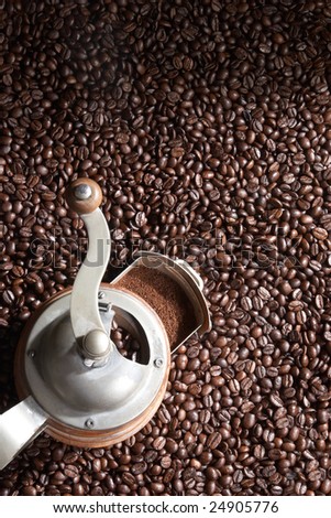 Brown coffee beans with coffee grinder covers the whole picture