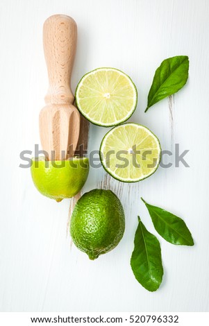 Fresh lime with citrus juicer stick. Preparation ingredient for cooking with lime. Making lime juice,easy and tasty refreshing drink that quenches thirst well on a hot day.lime juice cocktail recipes.