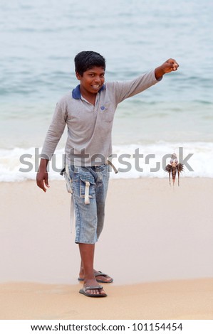 NAGAPATTINAM, SOUTH INDIA - FEBRUARY 11: Indian boy Pradip, 10, with poison lionfish poses for a foto during local Pongal Festival on February 11, 2010 in Nagapattinam, Tamil Nadu, South India