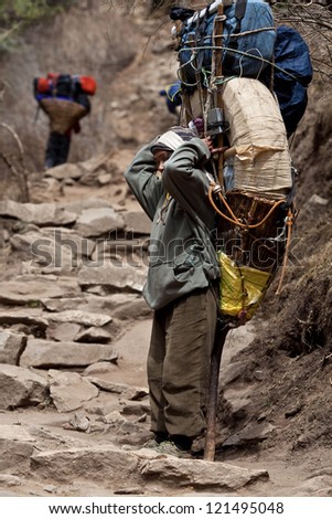SAGARMATHA NATIONAL PARK, NEPAL - MARCH 06: Porters carry heavy load in the Himalaya, Nepal on March 06, 2010 in Sagarmatha National Park, Nepal