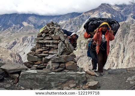 UPPER DOLPO, NEPAL - SEPTEMBER 16: Porters with heavy load at the Sangda Pass in time Russian ethnographic Expedition on September 16, 2011 in Upper Dolpo restricted area, Nepal