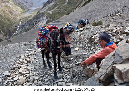 UPPER DOLPO, NEPAL - SEPTEMBER 16: Man with horse resting at the Pass in time Russian ethnographic Expedition on September 16, 2011 in Upper Dolpo restricted area, Nepal