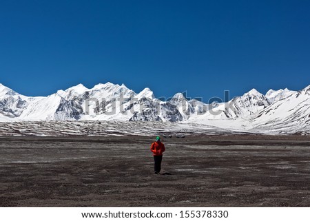 PEIKU TSO LAKE, TIBET - APRIL 26: An unidentified Russian tourist poses for a photo on the road to Nyalam on April 26, 2013 in Tibet Autonomus Region of China. The lake is 27 km long