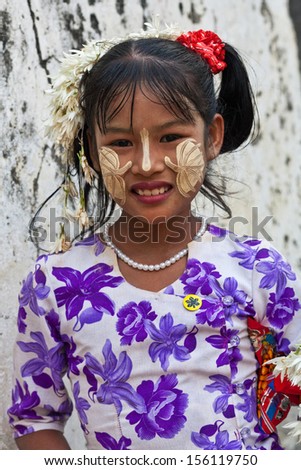MANDALAY, MYANMAR - JANUARY 09: Smiling girl Thin Moe, 10 with Thanaka paste on her face posing for the photo during the local Htamanu Festival on January 09, 2011 in Mandalay, Myanmar
