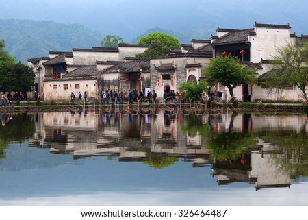 HONGCUN, CHINA - APRIL 20: Tourists walking around Moon Lake in Hongcun Village, China on April 20, 2014. Hongcun is ancient village in Anhui Province, near the southwest slope of Mount Huangshan.