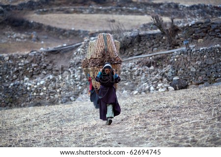 MANASLU AREA, NEPAL - NOVEMBER 28: Several tibetan womans in national clothes with basket on the road on November 28, 2009 in Gorkha District, Nepal.