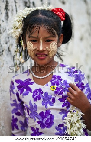 MANDALAY, MYANMAR - JANUARY 09: Smiling girl Thin Moe, 10 with thanaka paste on the face posing for the photo during the Mandalay Hta-Mane Festival on January 09, 2011 in Mandalay, Myanmar