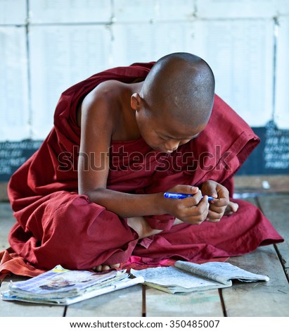 NYAUNG SHWE, SHAN STATE, MYANMAR - JANUARY 16: Novice monk learning in class room of Shwe Yan Pyay monastery school on January 16, 2011 in Nyaung Shwe, Myanmar
