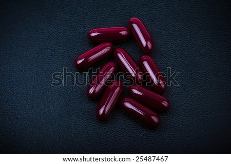 Dark red pills on black