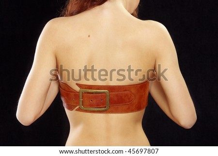 beautiful woman\'s back covered with leather belt