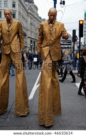 LONDON - DECEMBER 5: Two golden men on stilts  at Shop West End VIP (Very Important Pedestrians) Day in London West End, December 05, 2009 in London, England.