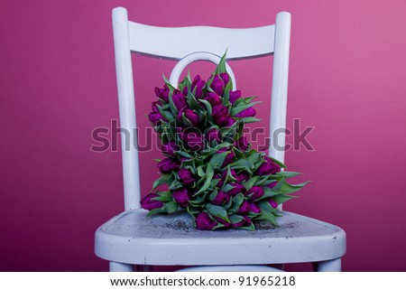 Purple tulips bouqet on white chair