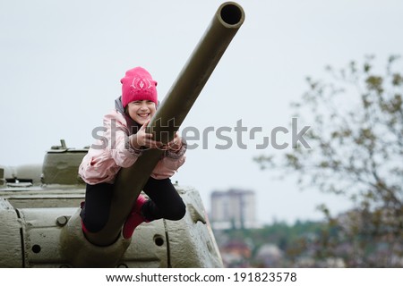 DONETSK, UKRAINE - MAY 9: Kid playing around soviet tanks and artillery during celebration of the Victory Day near \