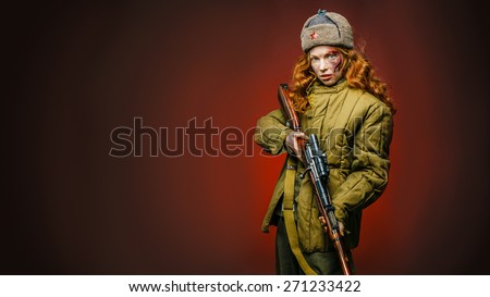 Historical reenactment of soviet union army by pretty girl with mosin-nagan in beautiful light on red background