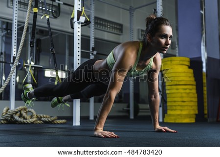 Concept: power, strength, healthy lifestyle, sport. Powerful attractive muscular woman CrossFit trainer stand in plank during workout at the gym