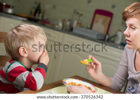 Blond Boy Holds Hand on his Mouth to Stop Eating