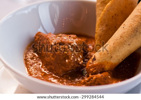Mexican beef mole with sesame seeds and fried tortillas