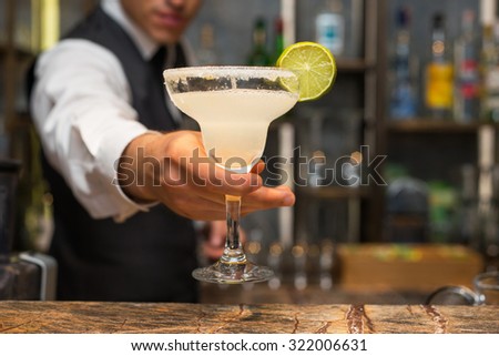 Barman serving margarita cocktail