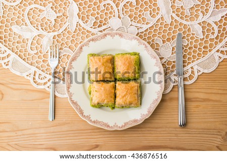 Turkish dessert baklava with pistachio on a rustic tablecloth.top view