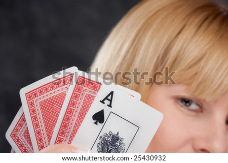 Blond woman with playing cards show ace spade