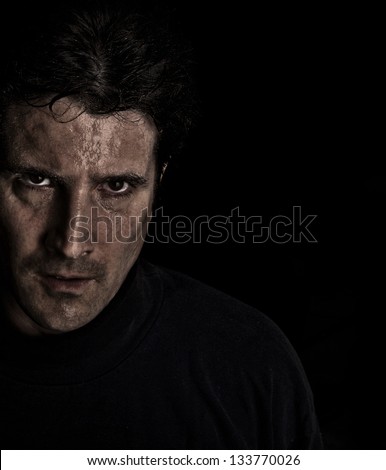 A violent, angry man stares with intense hatred.