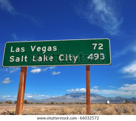 Funny contrast of cities on a road sign.