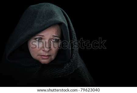 Dramatic image of a sad woman draped in a shawl.