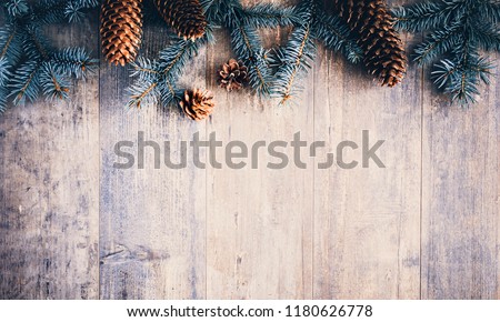 Christmas composition. Frame made of pine branches, fir cones on rustic vintage wooden background. Flat lay, top view, copy space.