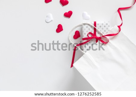 Valentine\'s Day background. White paper bag, red hearts and  gift on white background. Valentine day concept.