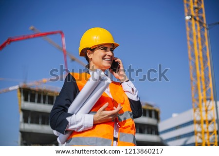 Young architect at his workplace on the site. He controls work and make suggestions workers.