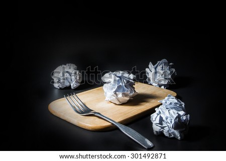 Fork and crumpled paper on black background. Business frustrations, Job stress and Failed exam concept.