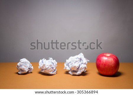 an apple and crumpled paper. Business frustrations, Job stress and Failed exam concept.