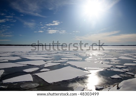 A winter landscape in the sunlight with packed ice in the sea.