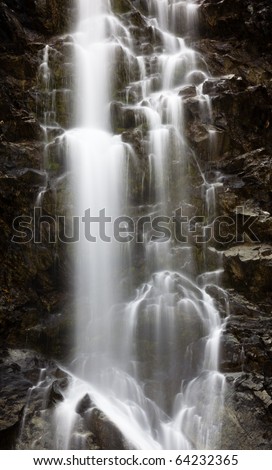 A stream of water falling down a rocky mountainside. Long exposure.