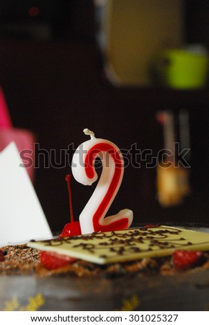 Numeral Candle No. 2 on Chocolate Birthday Cake.. Two years or anniversary..